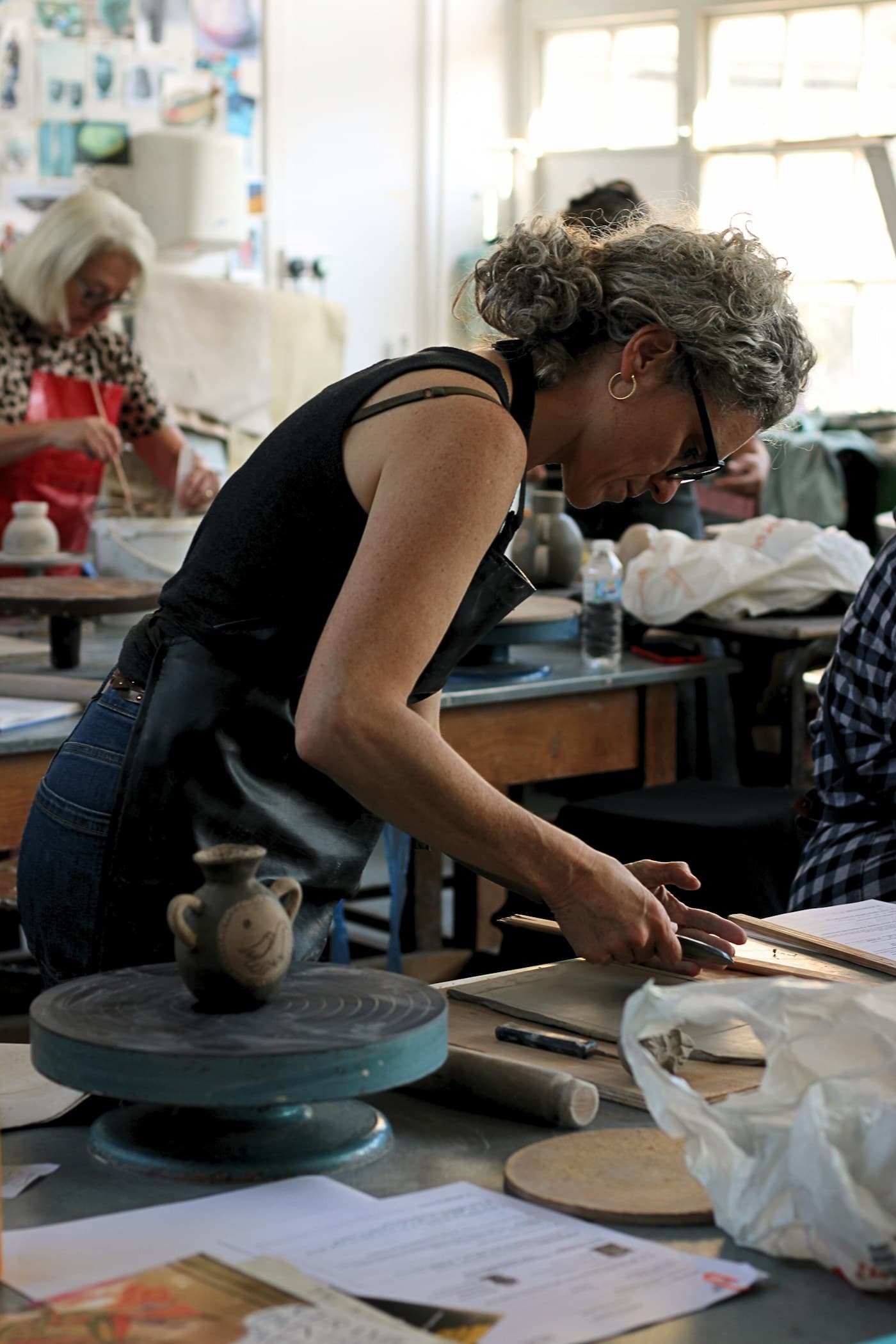 A maker working with clay in a studio